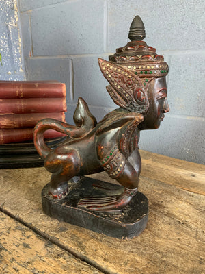 A carved wooden Manussiha sphinx statue