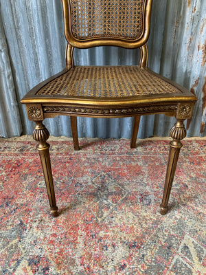 A rococo-style giltwood cane chair