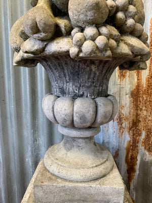 A cast stone cornucopia on plinth