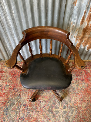 A spindle back captain's desk chair
