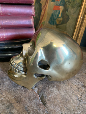 A life-size brass human skull model