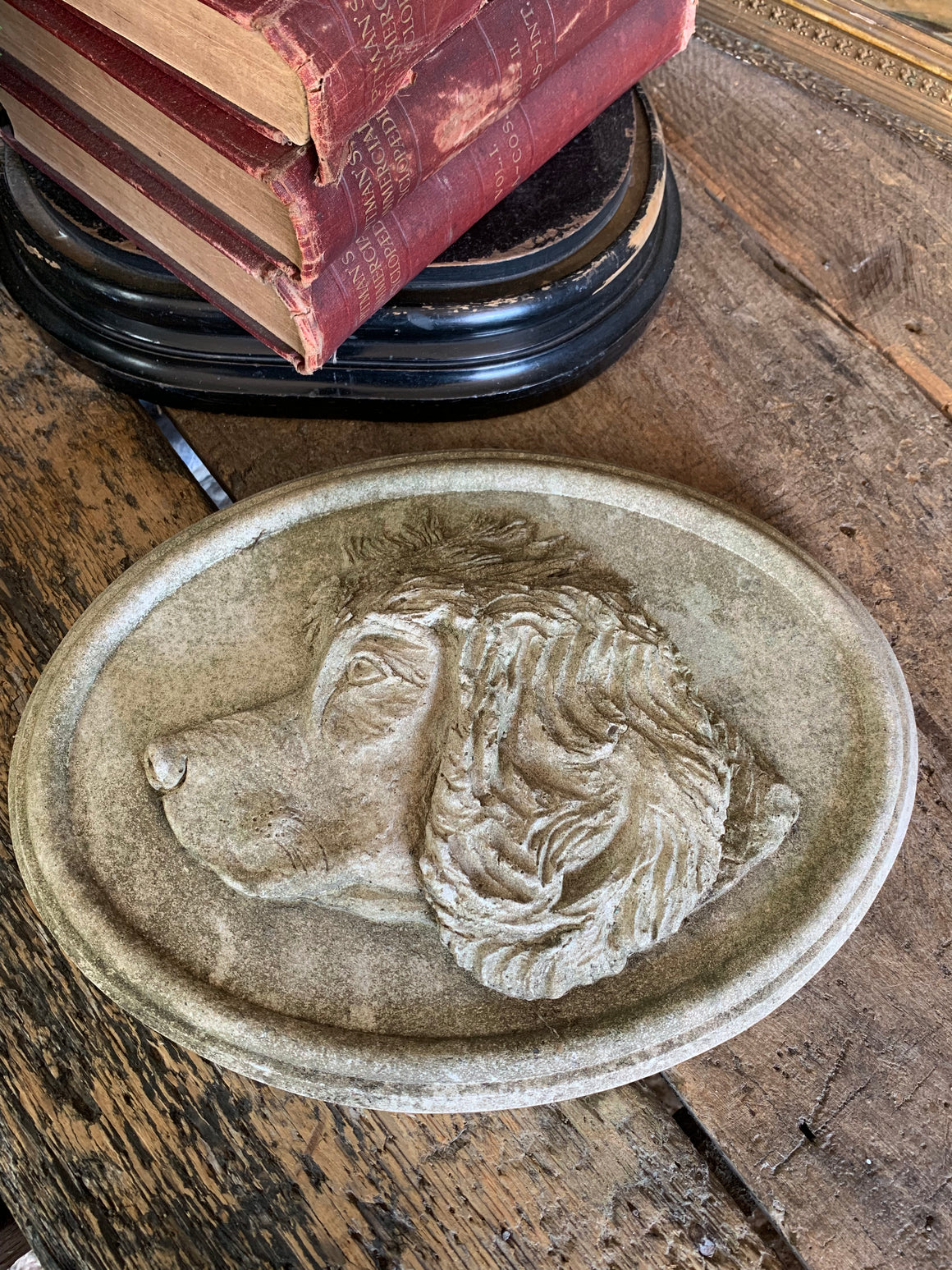 An oval cast stone plaque depicting a dog's head in profile ~A