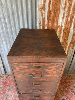 A large wooden filing cabinet with four drawers