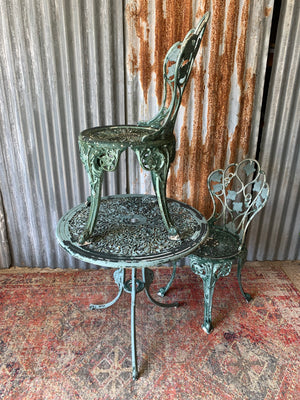 A green garden table and two chair bistro set