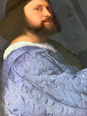 A large framed print of Titian's "Portrait of a Man"