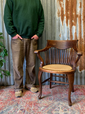 A banker's chair with caned seat