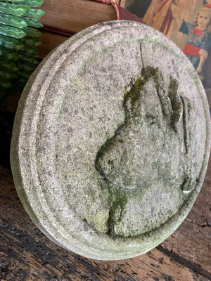 An oval cast stone plaque depicting a dog's head in profile ~C