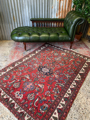 A Victorian-style green leather chaise longue