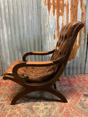 A brown leather button back slipper chair