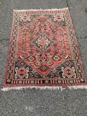 A Persian red ground rectangular rug- 161cm x 117cm