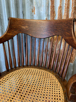 A banker's chair with caned seat