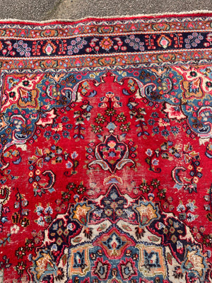 A large red ground Persian rug - 299cm x 194cm