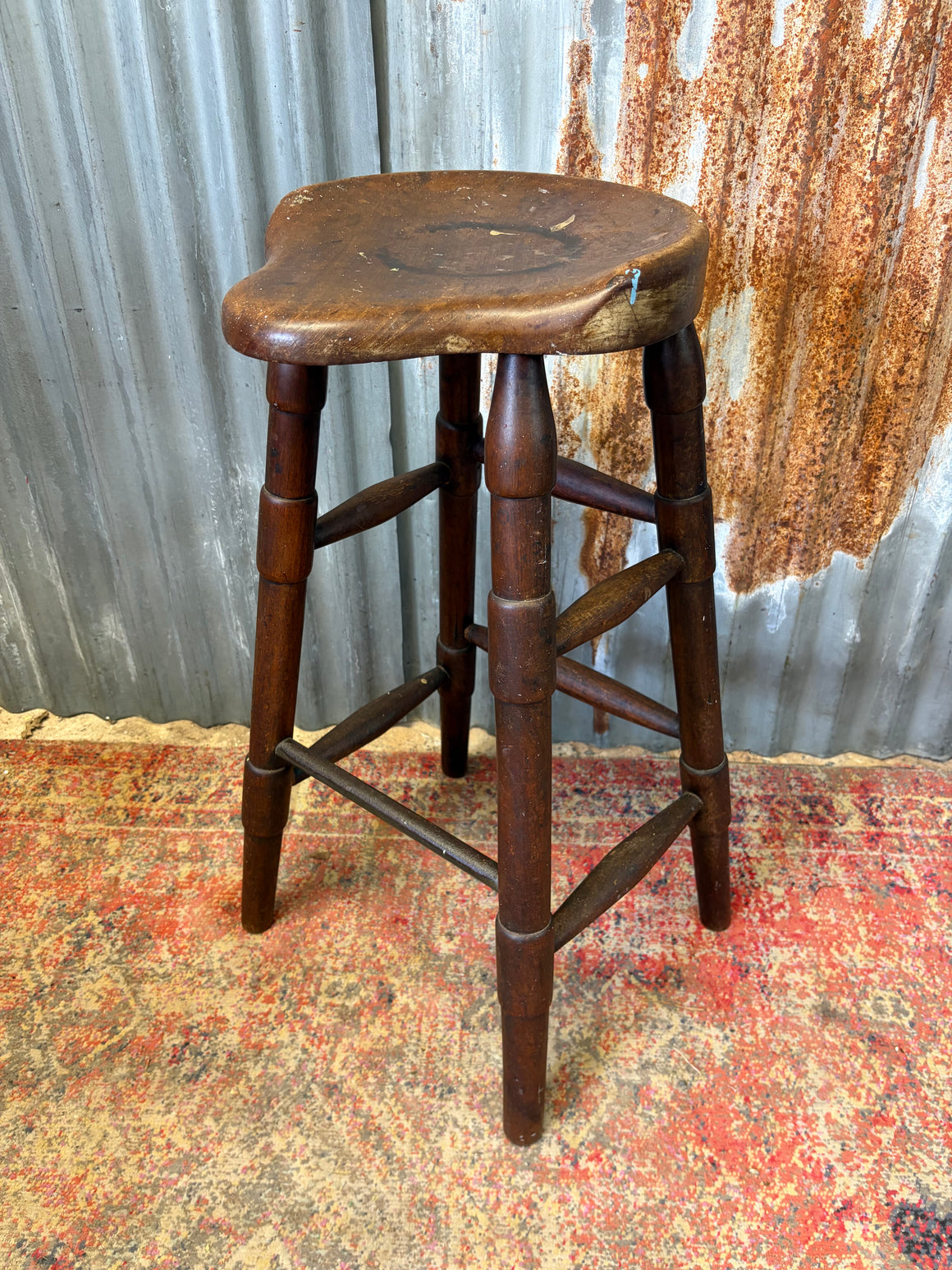 An elm and cast iron saddle stool