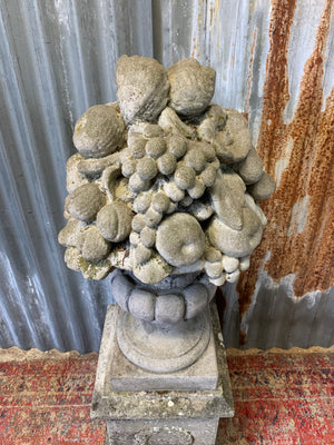 A cast stone cornucopia on plinth