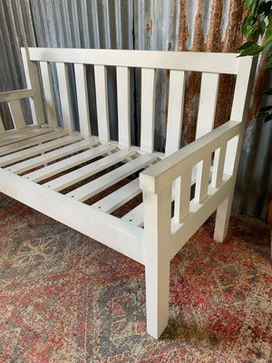 A large slatted wooden garden bench