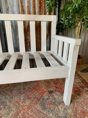 A large slatted wooden garden bench