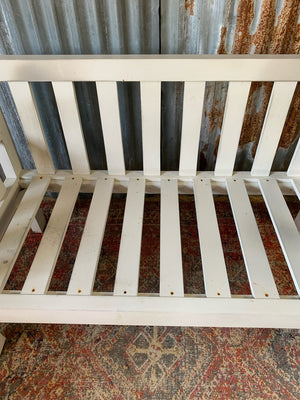 A large slatted wooden garden bench