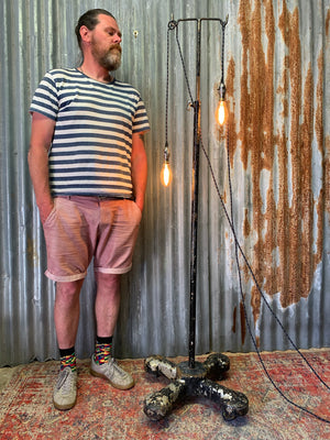 A vintage industrial floor lamp created from a hospital drip stand