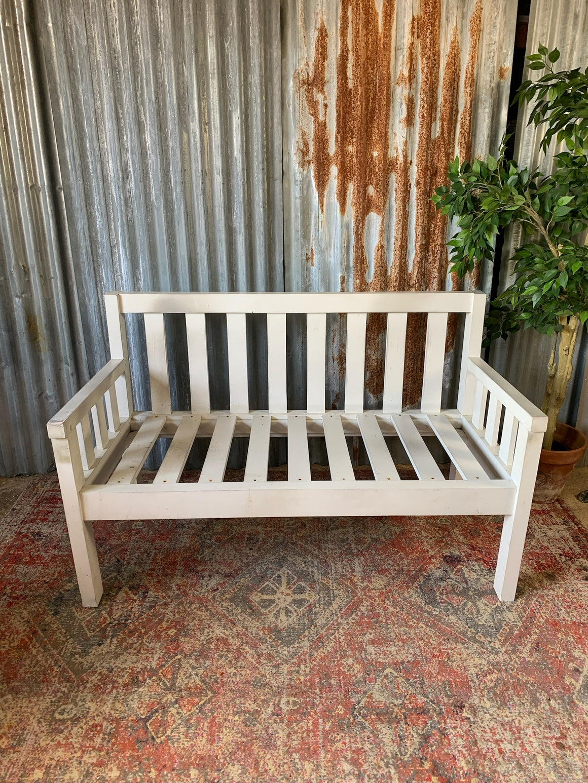 A large slatted wooden garden bench