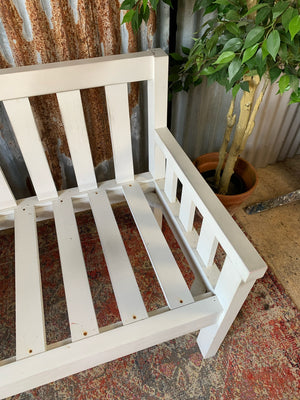 A large slatted wooden garden bench