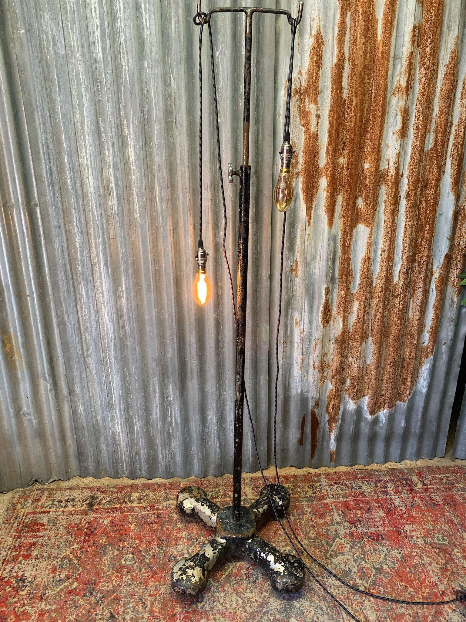 A vintage industrial floor lamp created from a hospital drip stand