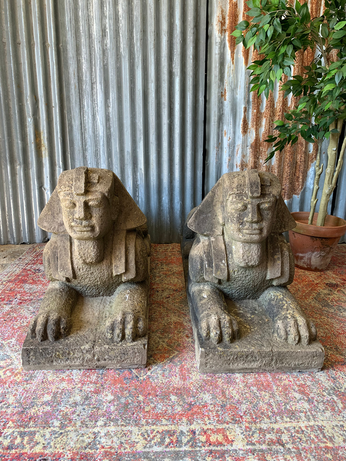 A pair of large faux stone Sphinx statues
