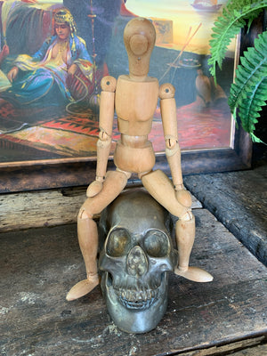A wooden artist's lay figure mounted on a stand