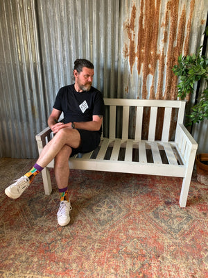 A large slatted wooden garden bench