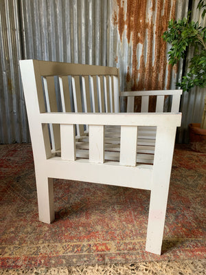 A large slatted wooden garden bench