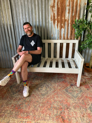 A large slatted wooden garden bench