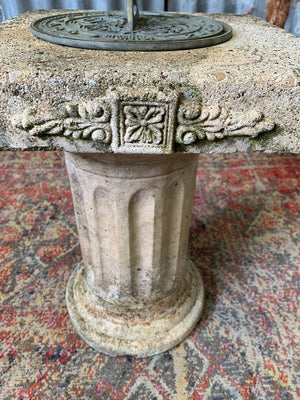 A large cast stone sundial on a column stand