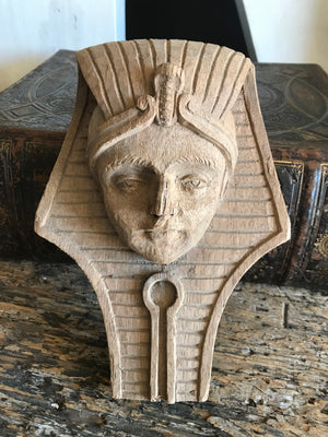 A hand-carved wooden Egyptian pharaoh head plaque