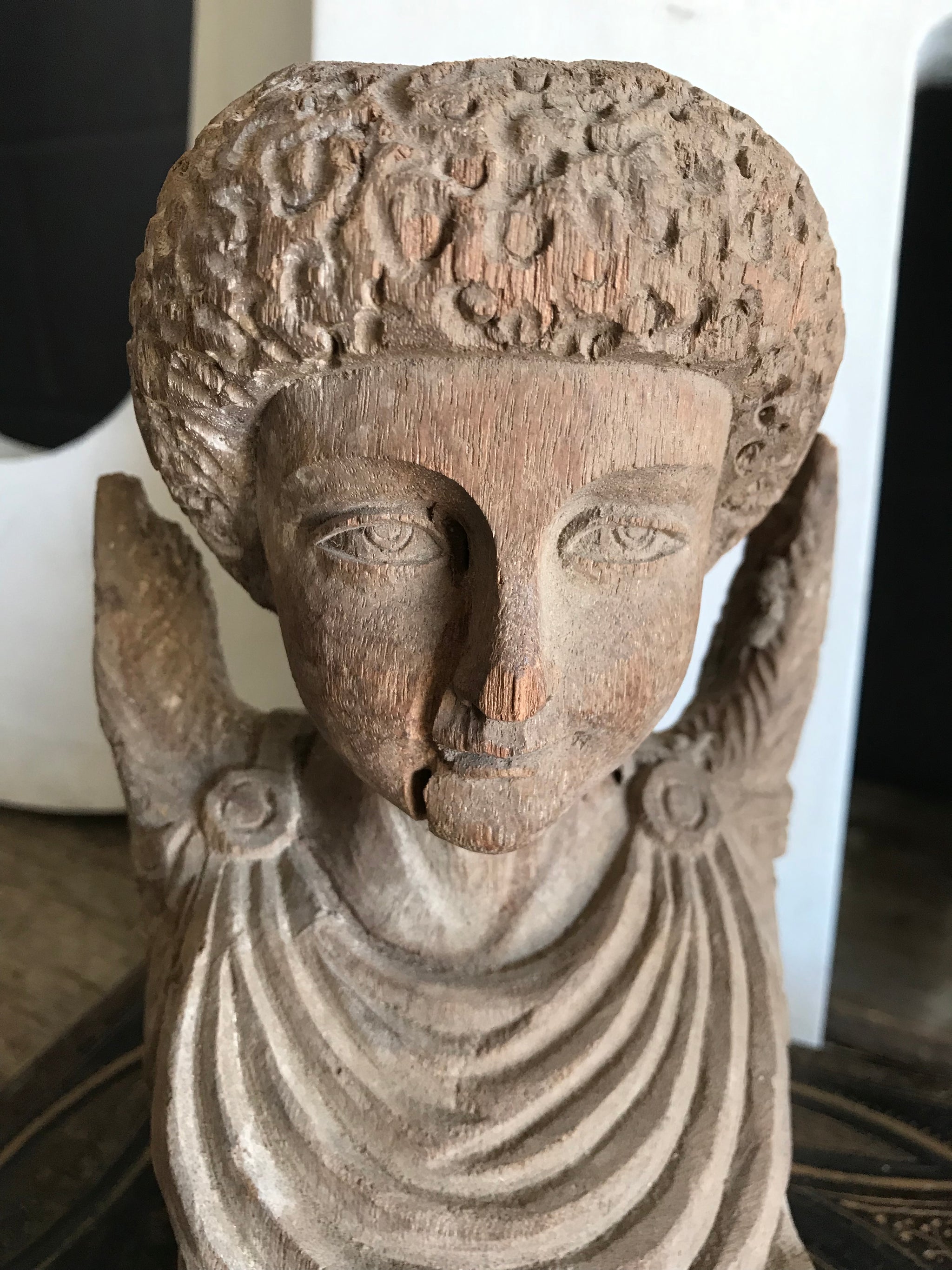 A hand-carved wooden cherub bust