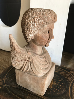 A hand-carved wooden cherub bust