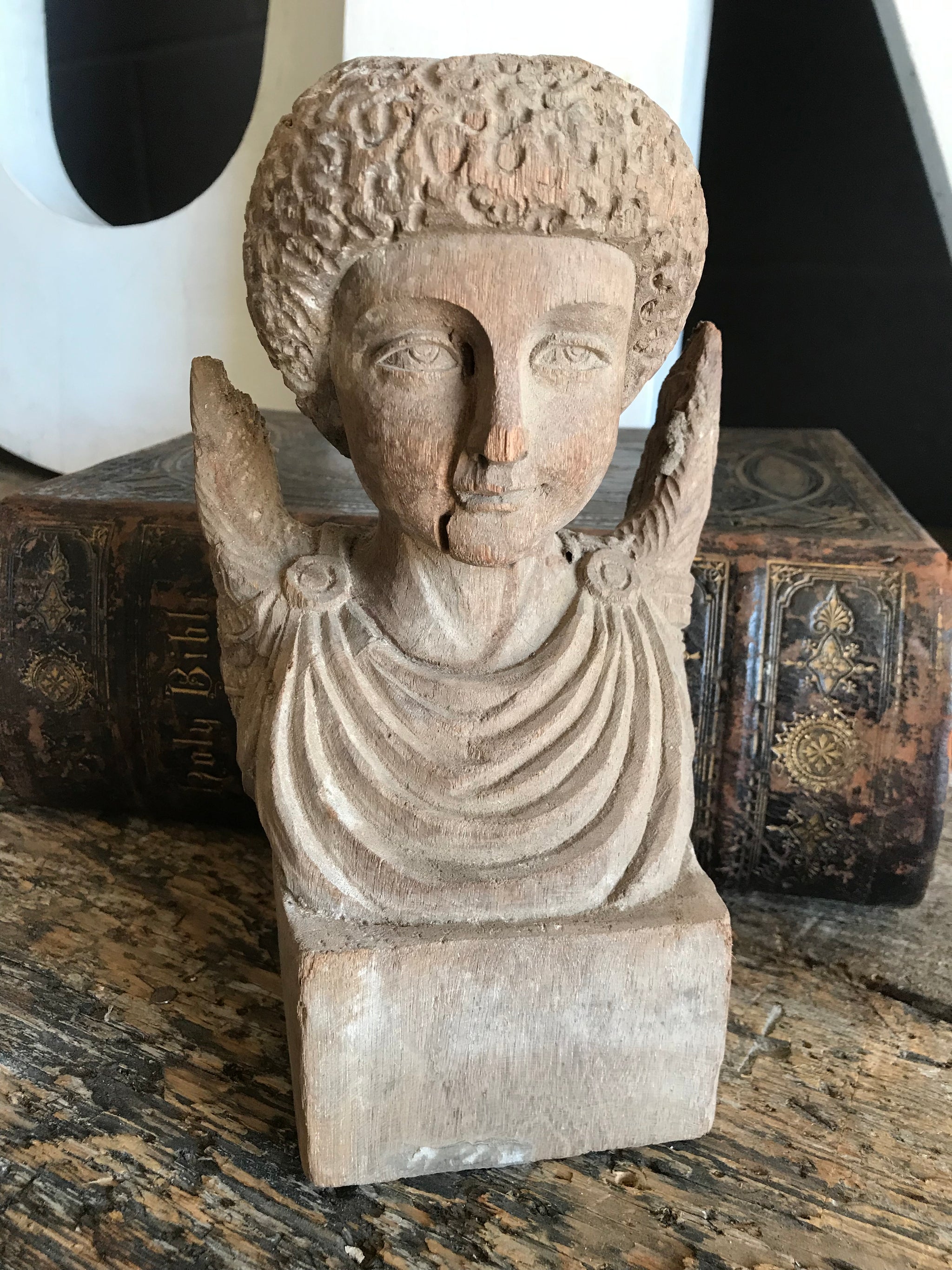 A hand-carved wooden cherub bust