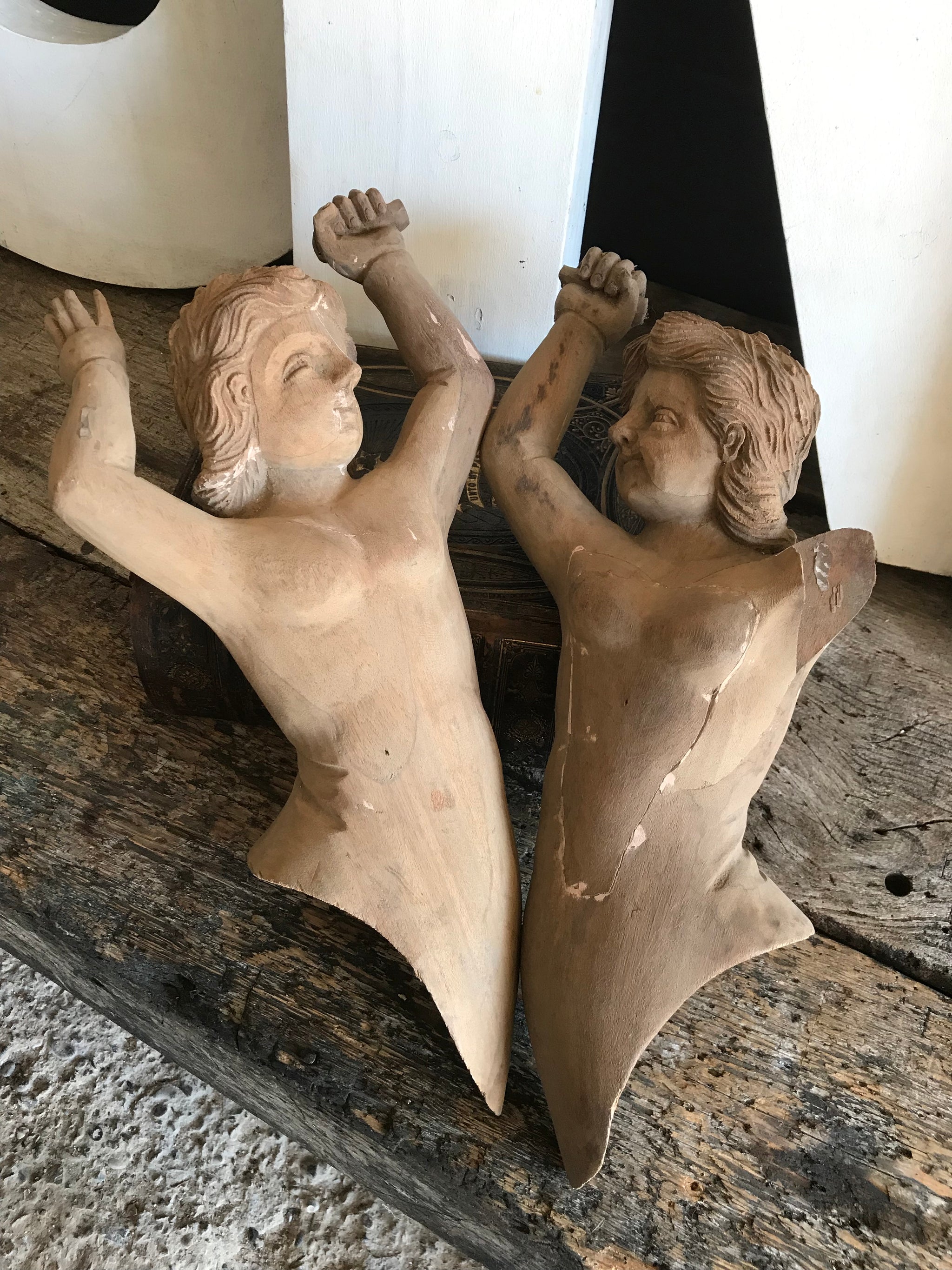 A pair of wooden hand-carved cherub figures