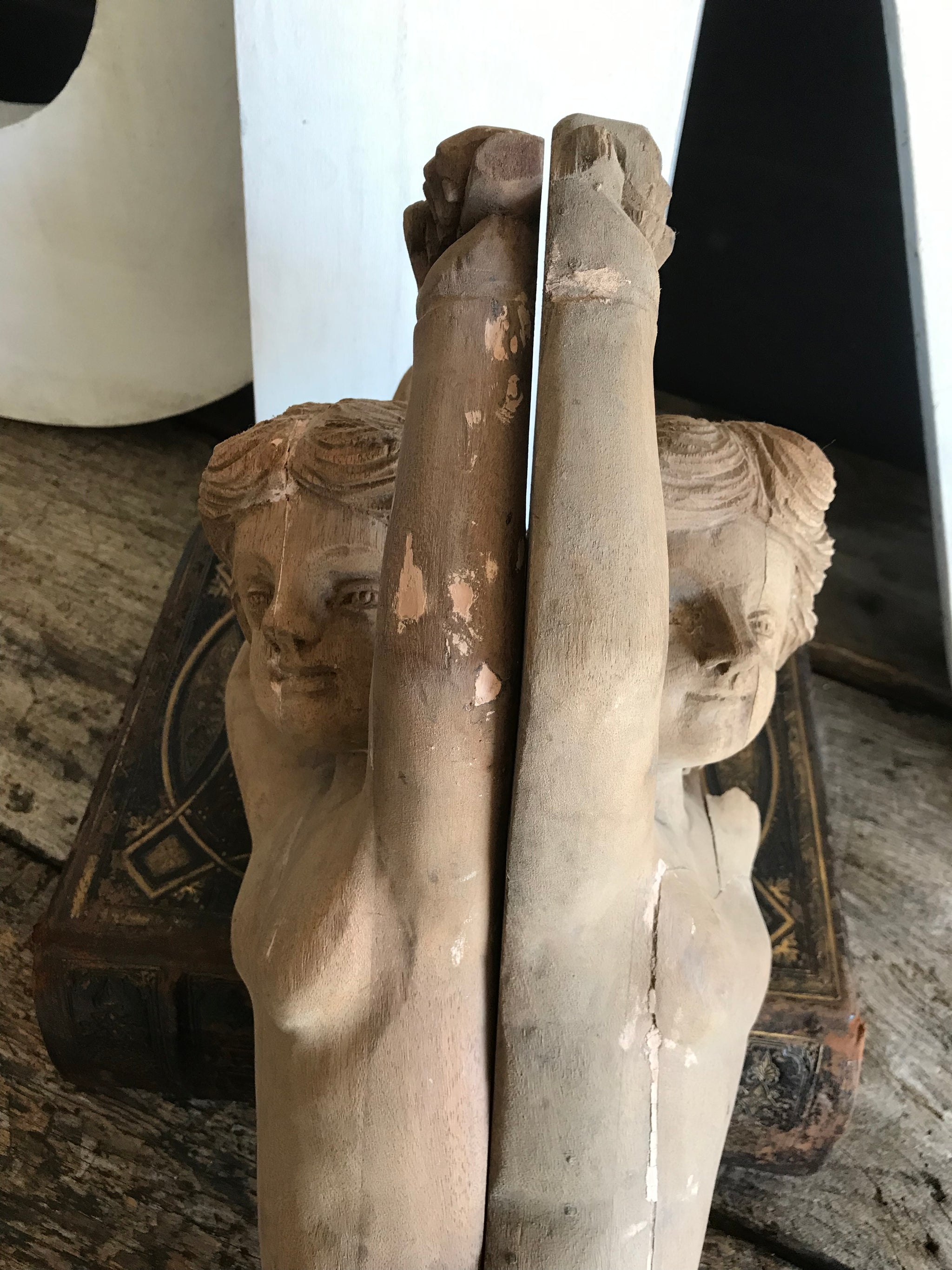 A pair of wooden hand-carved cherub figures