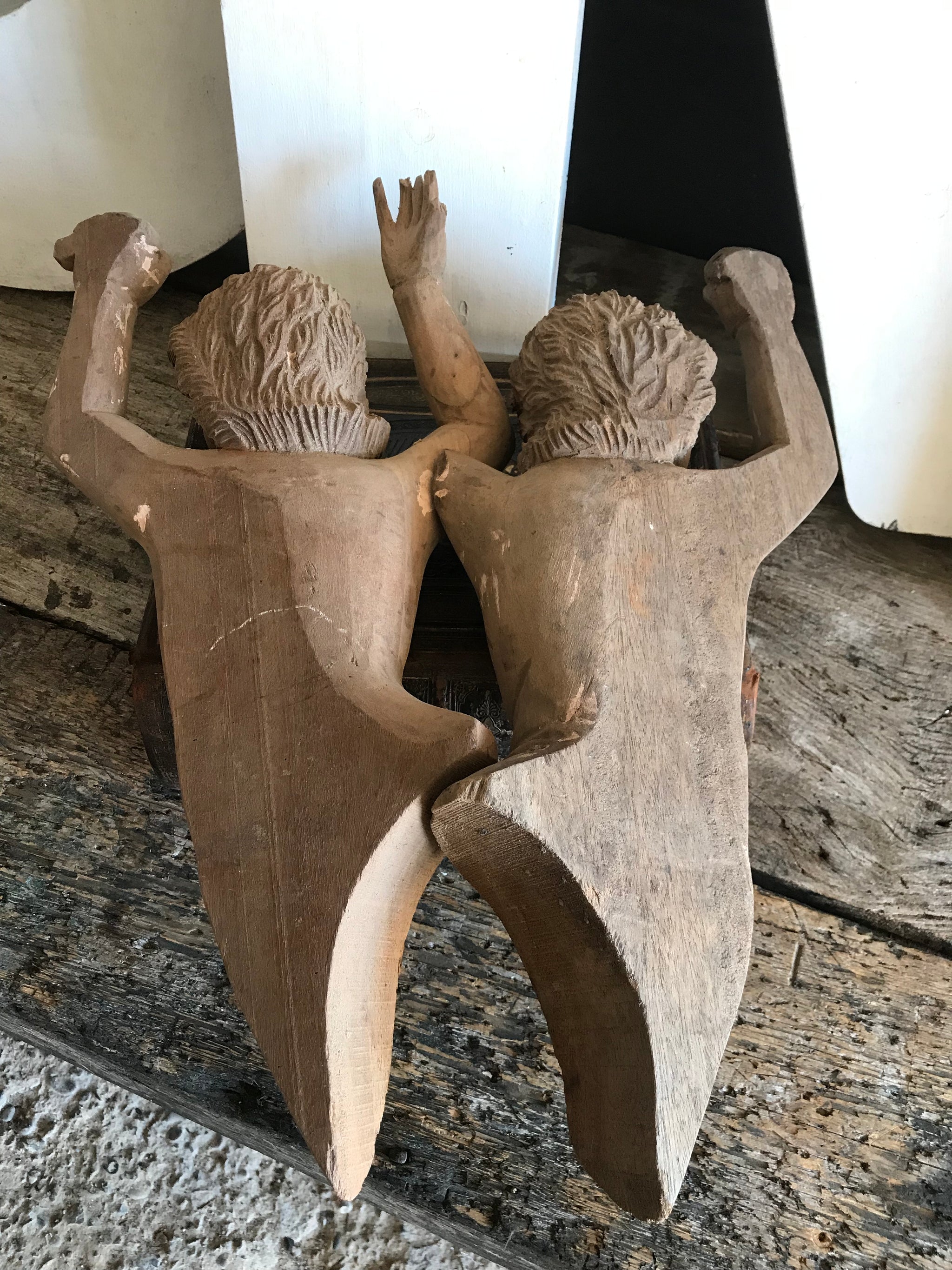 A pair of wooden hand-carved cherub figures