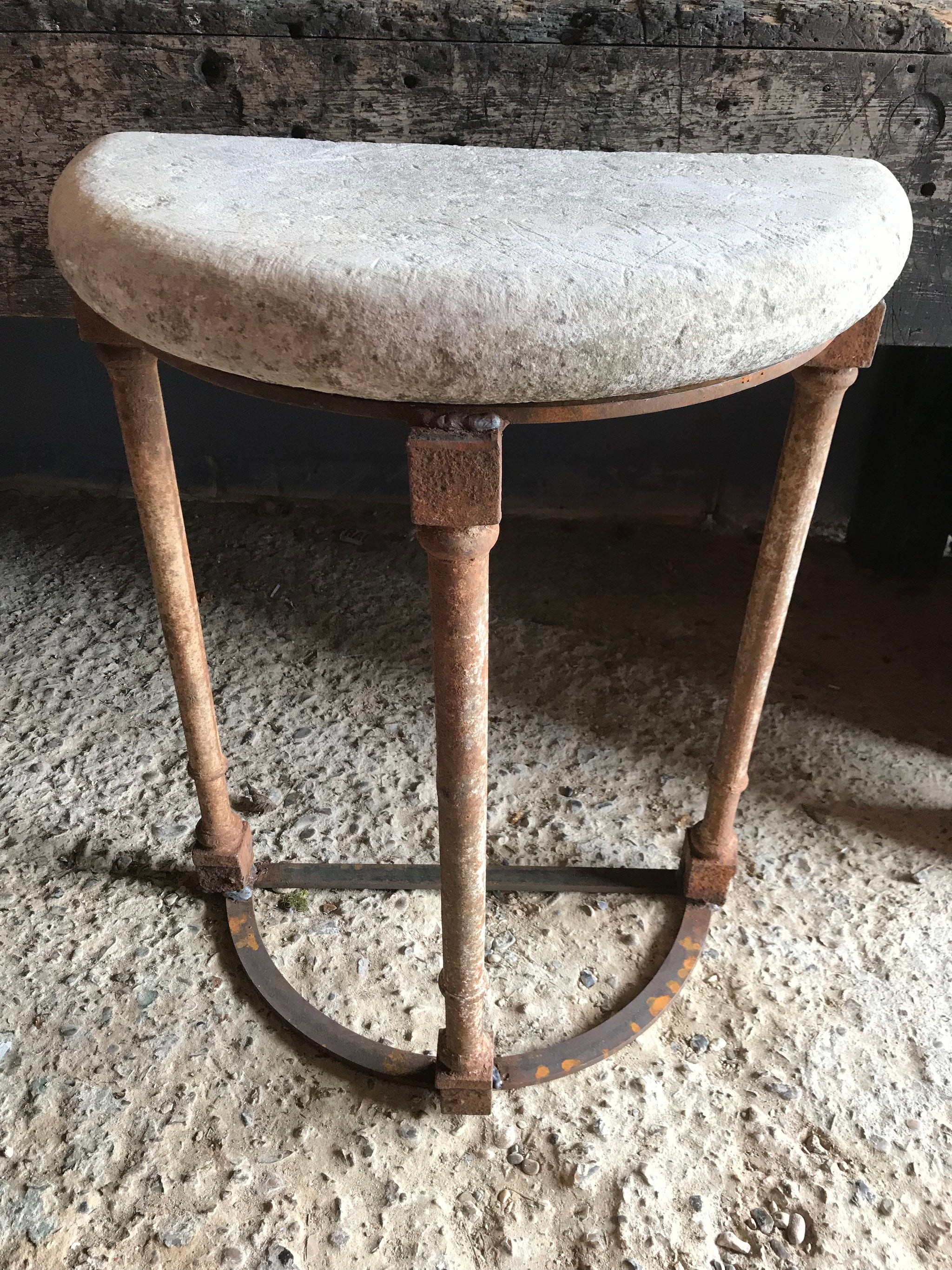 A pair of demilune cast iron and stone tables