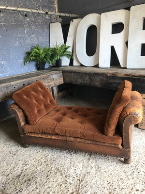 A brown leather art deco French daybed with drop arms and velvet cushions