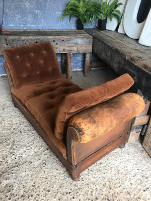 A brown leather art deco French daybed with drop arms and velvet cushions