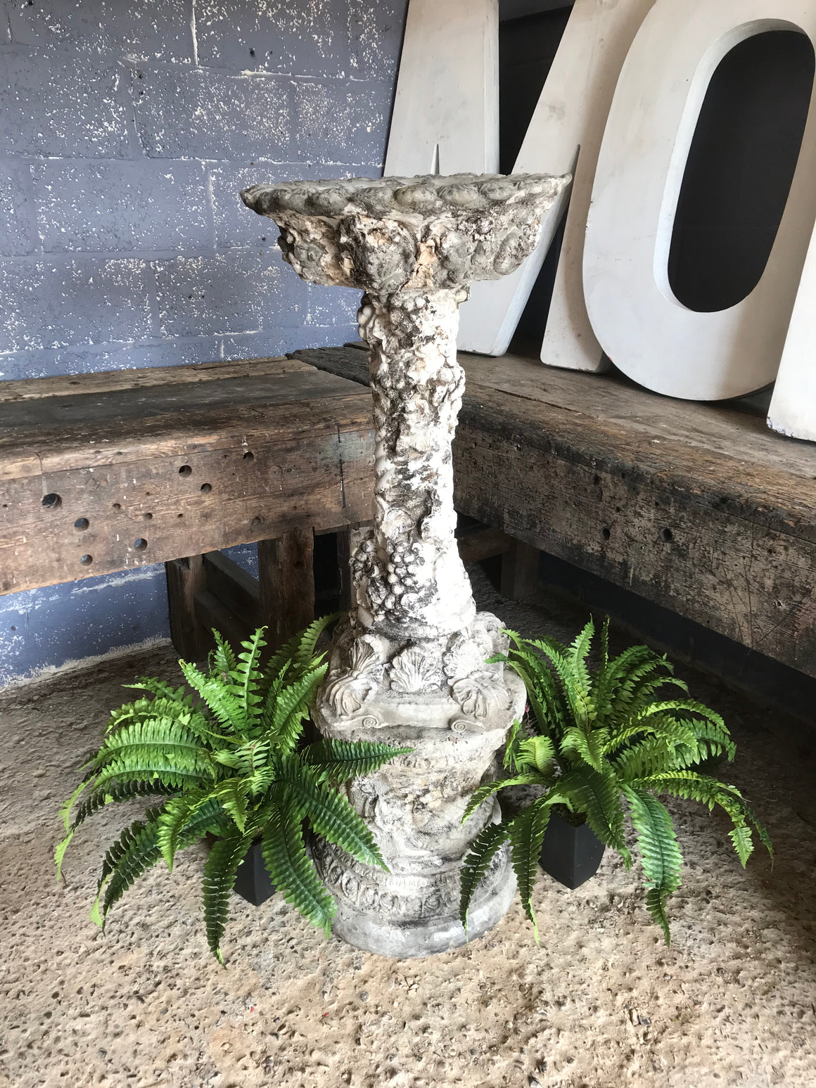 A large Greco Roman bird bath with ornate column