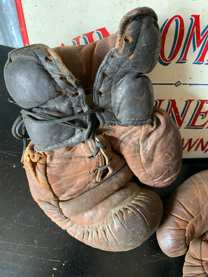 A vintage pair of large brown leather boxing gloves