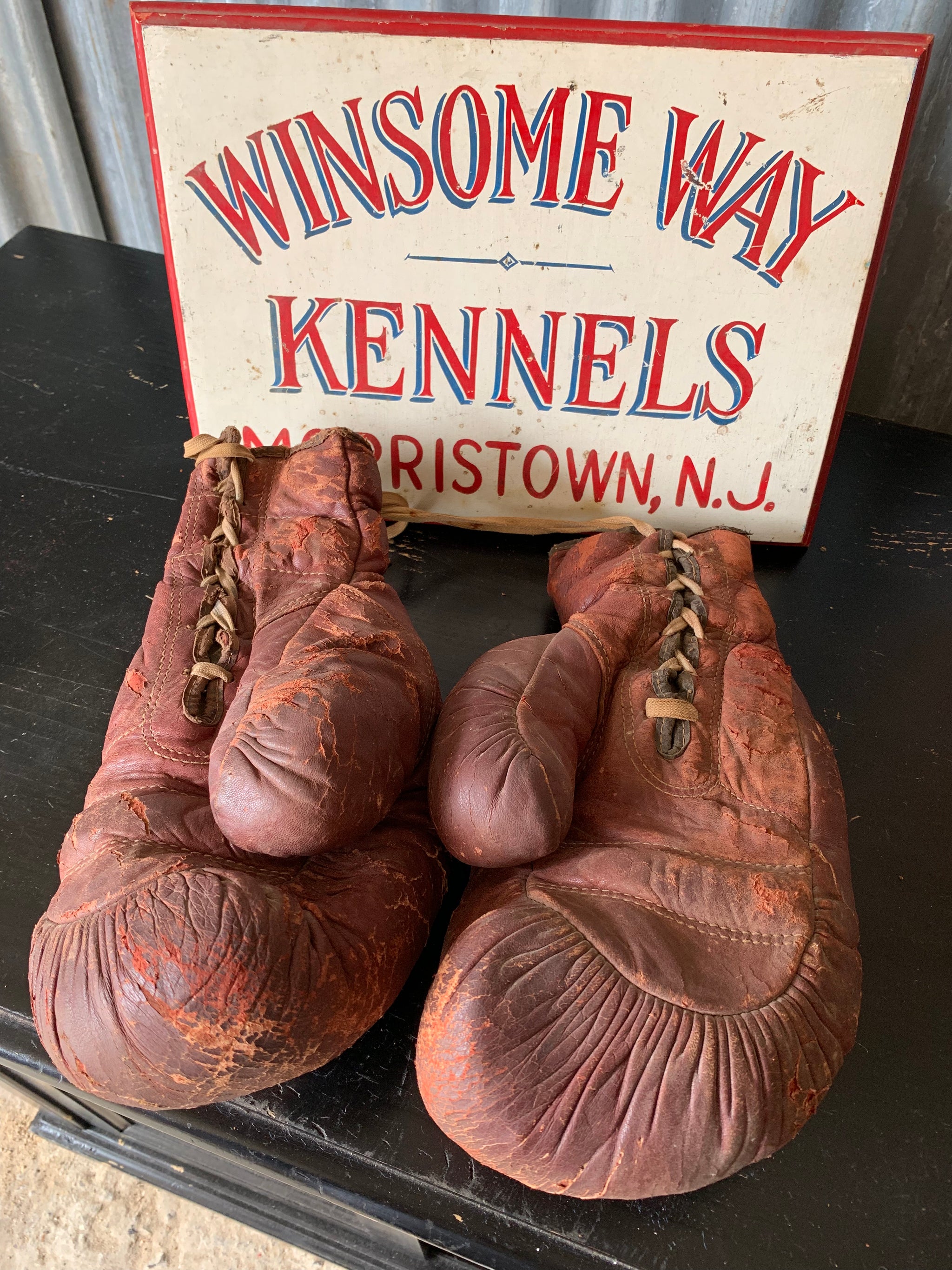A vintage pair of large red leather boxing gloves