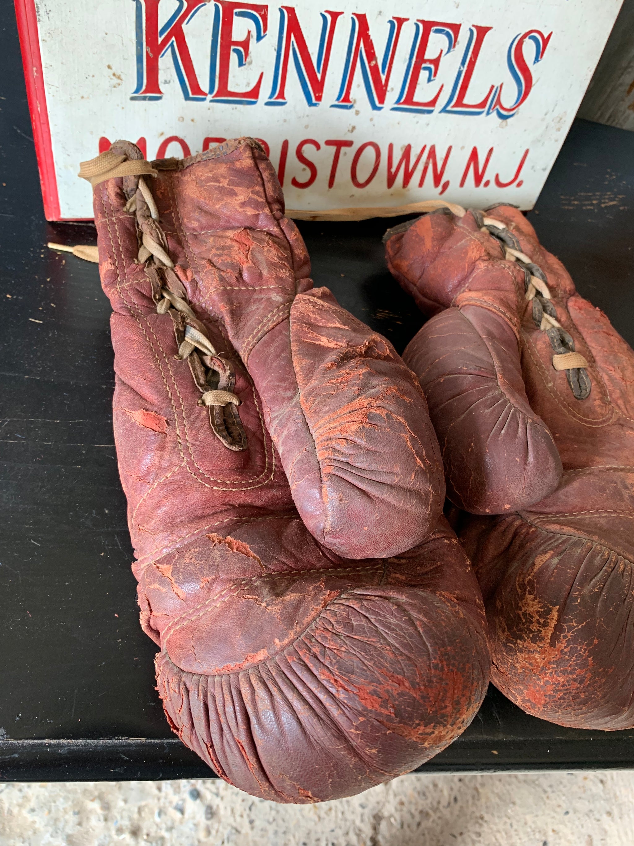 A vintage pair of large red leather boxing gloves