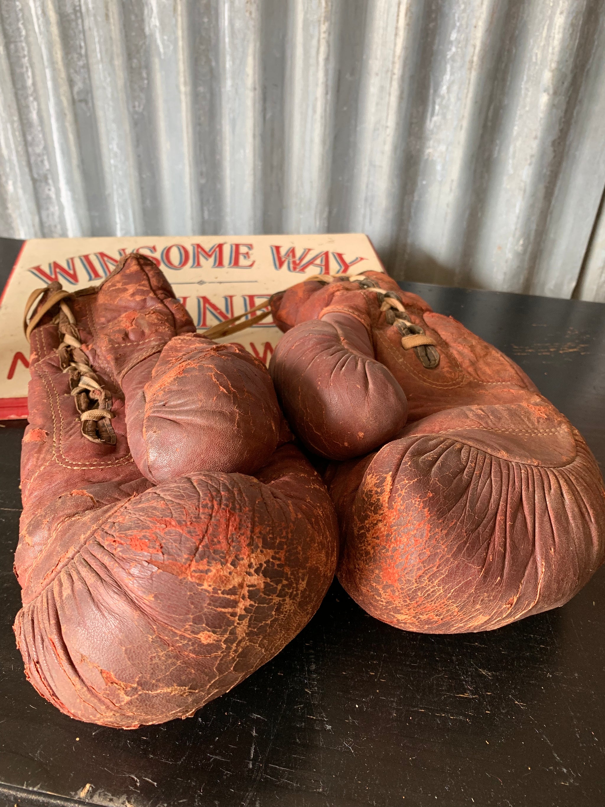 A vintage pair of large red leather boxing gloves