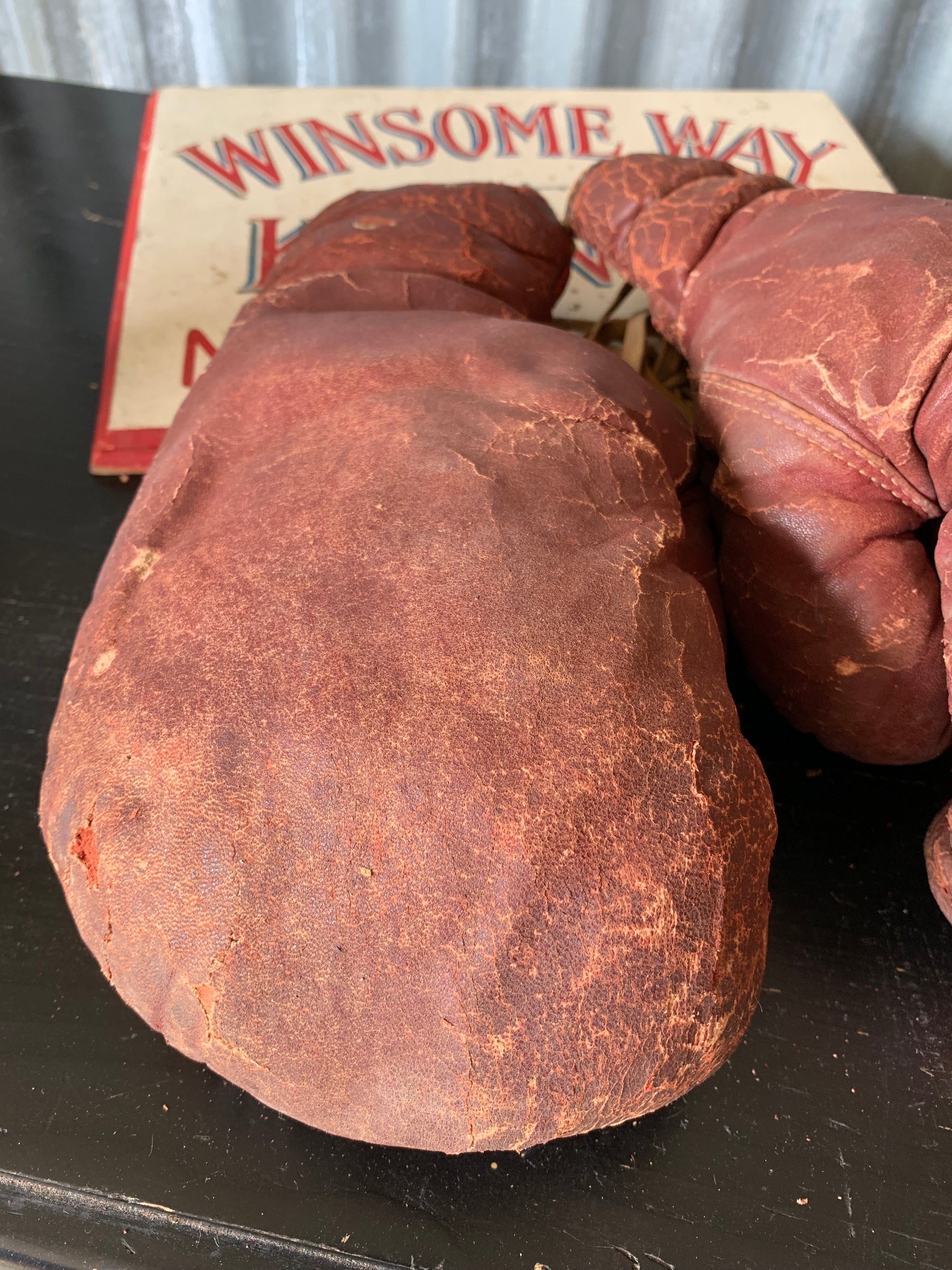 A vintage pair of large red leather boxing gloves
