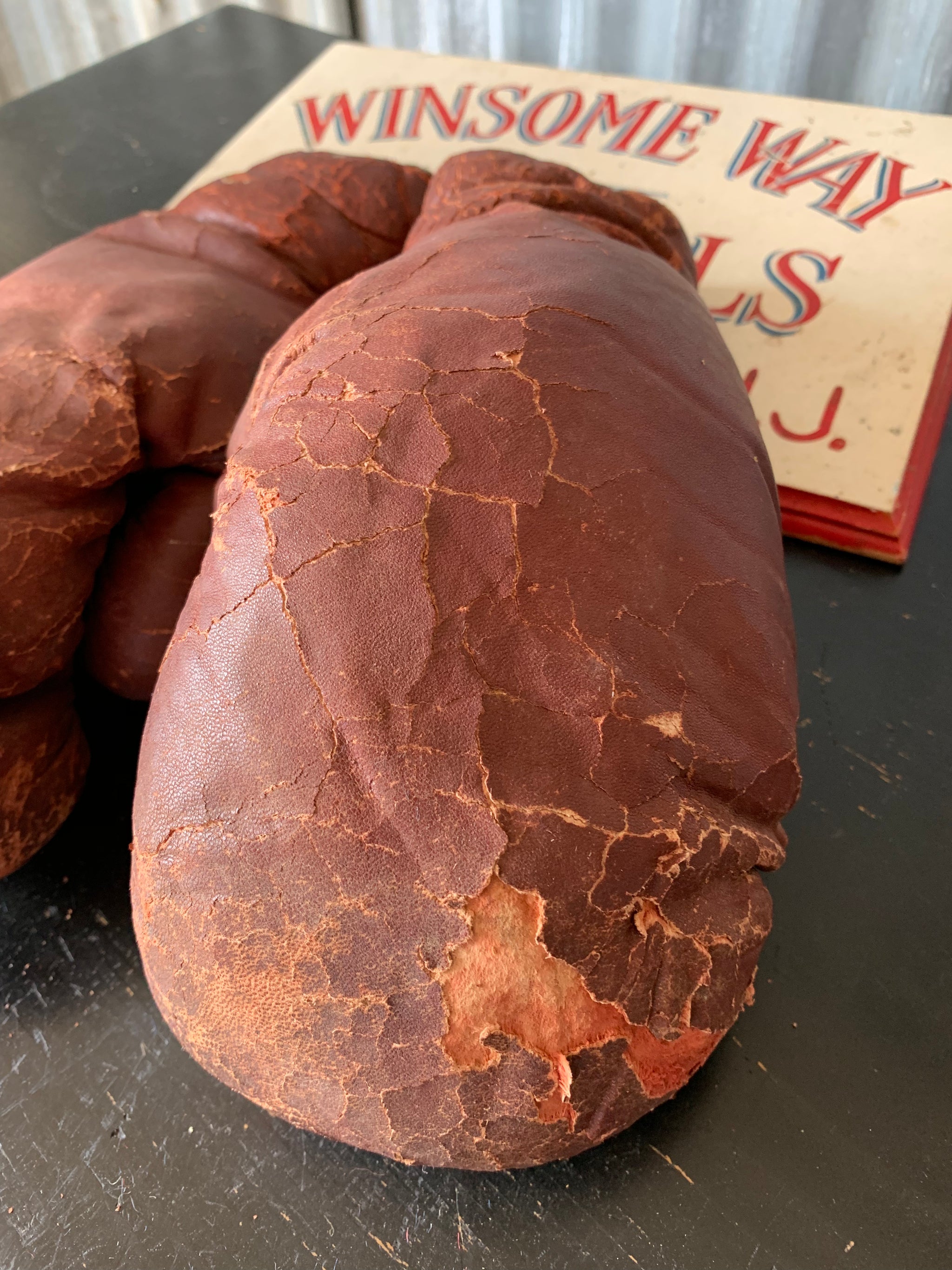 A vintage pair of large red leather boxing gloves
