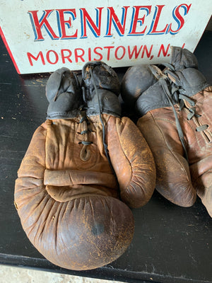 A vintage pair of large brown leather boxing gloves