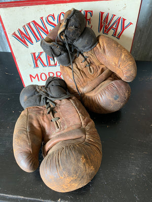 A vintage pair of large brown leather boxing gloves